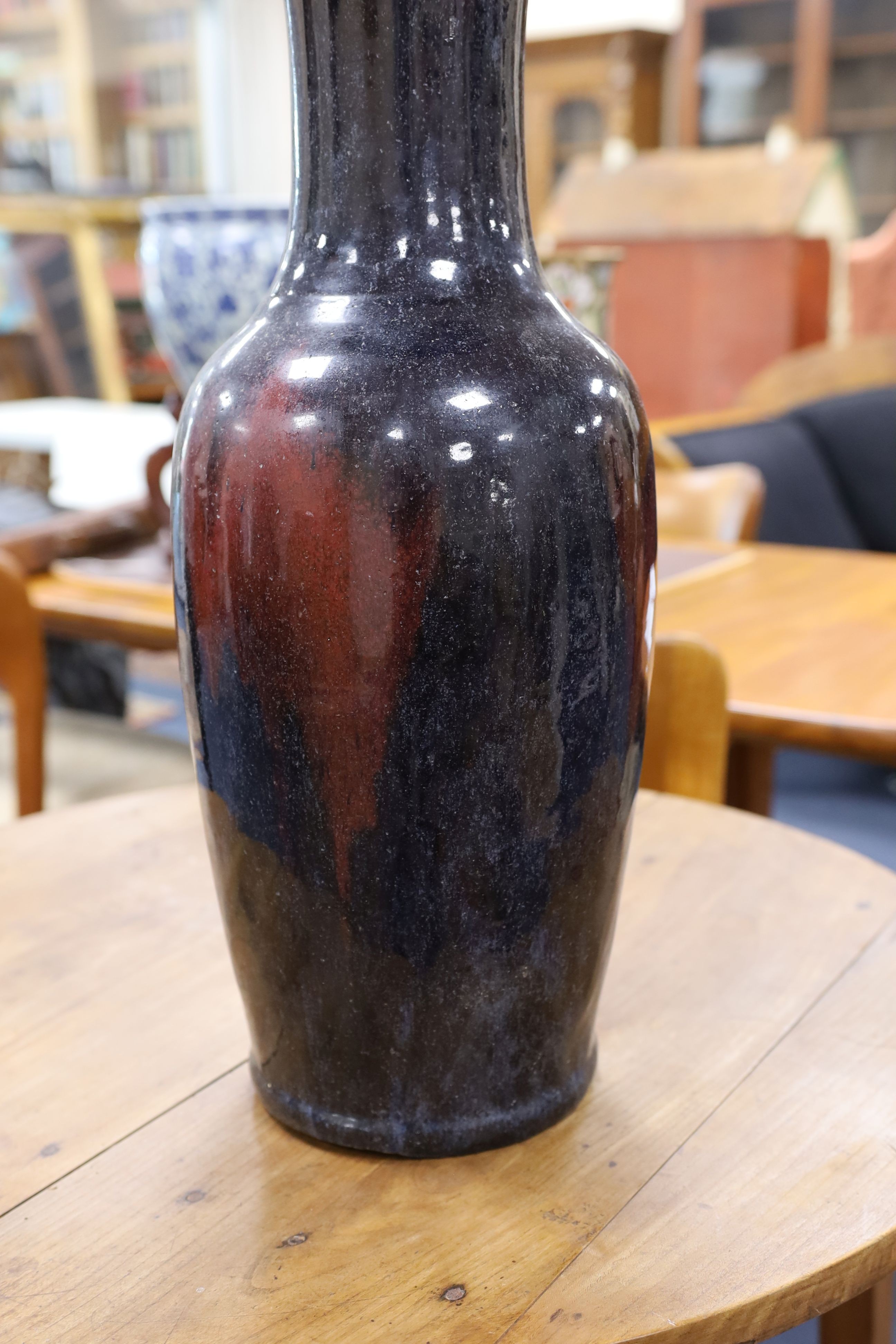 A large Chinese sang de boeuf glazed vase on carved wooden stand., Vase 61 cms high not including stand.